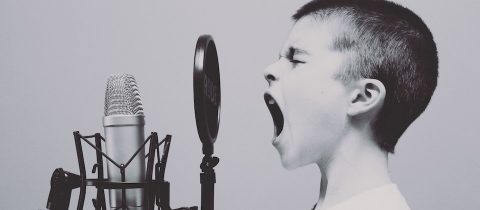 Boy shouting into a microphone, making an announcement