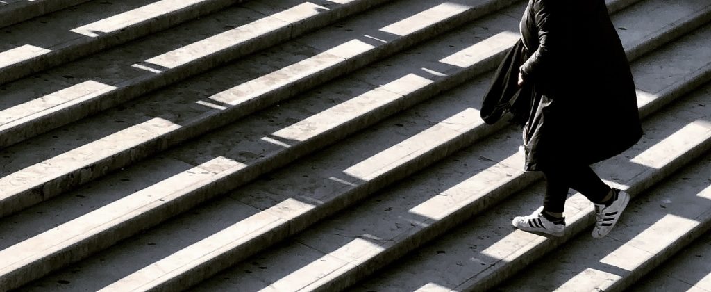 Person walking upstairs to symbolize starting small and then scaling up