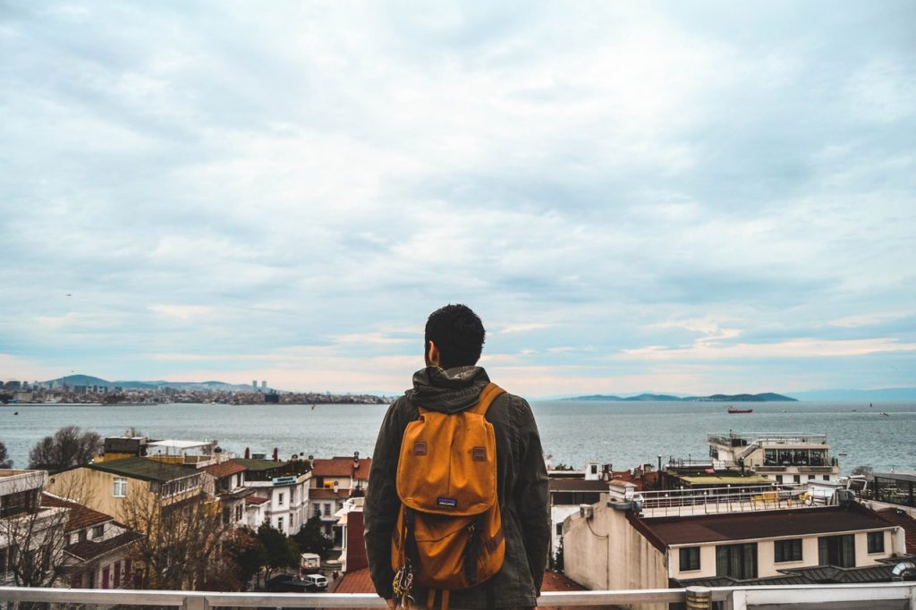 man wearing black jacket and brown backpack 860562 1